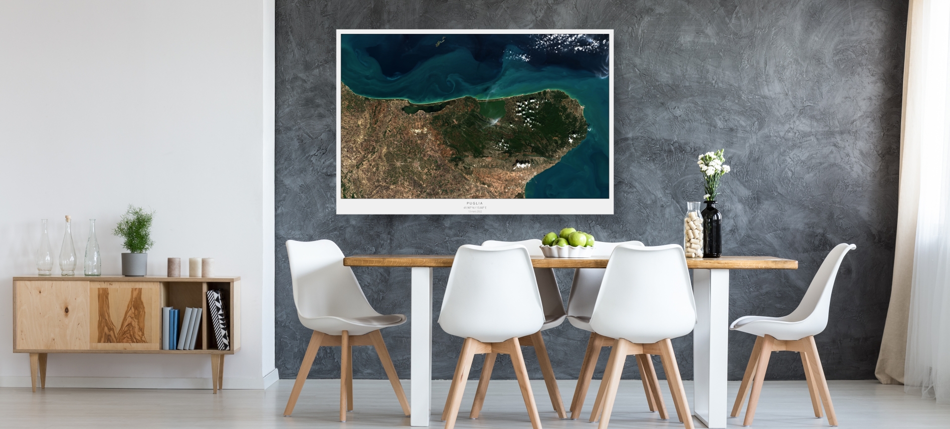 Photo of a dining room with a poster of a satellite image of Puglia in Italy on the wall